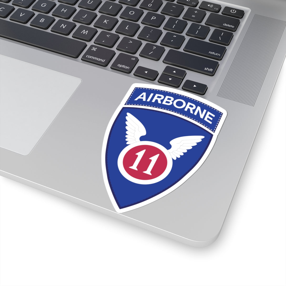 A kiss-Cut Stickers depicting the The 11th Airborne Division, known as the "Angels," is a historic U.S. Army airborne unit. Its shoulder sleeve insignia (SSI) features a red winged sword (symbolizing speed and striking power) on a blue background with a white border.