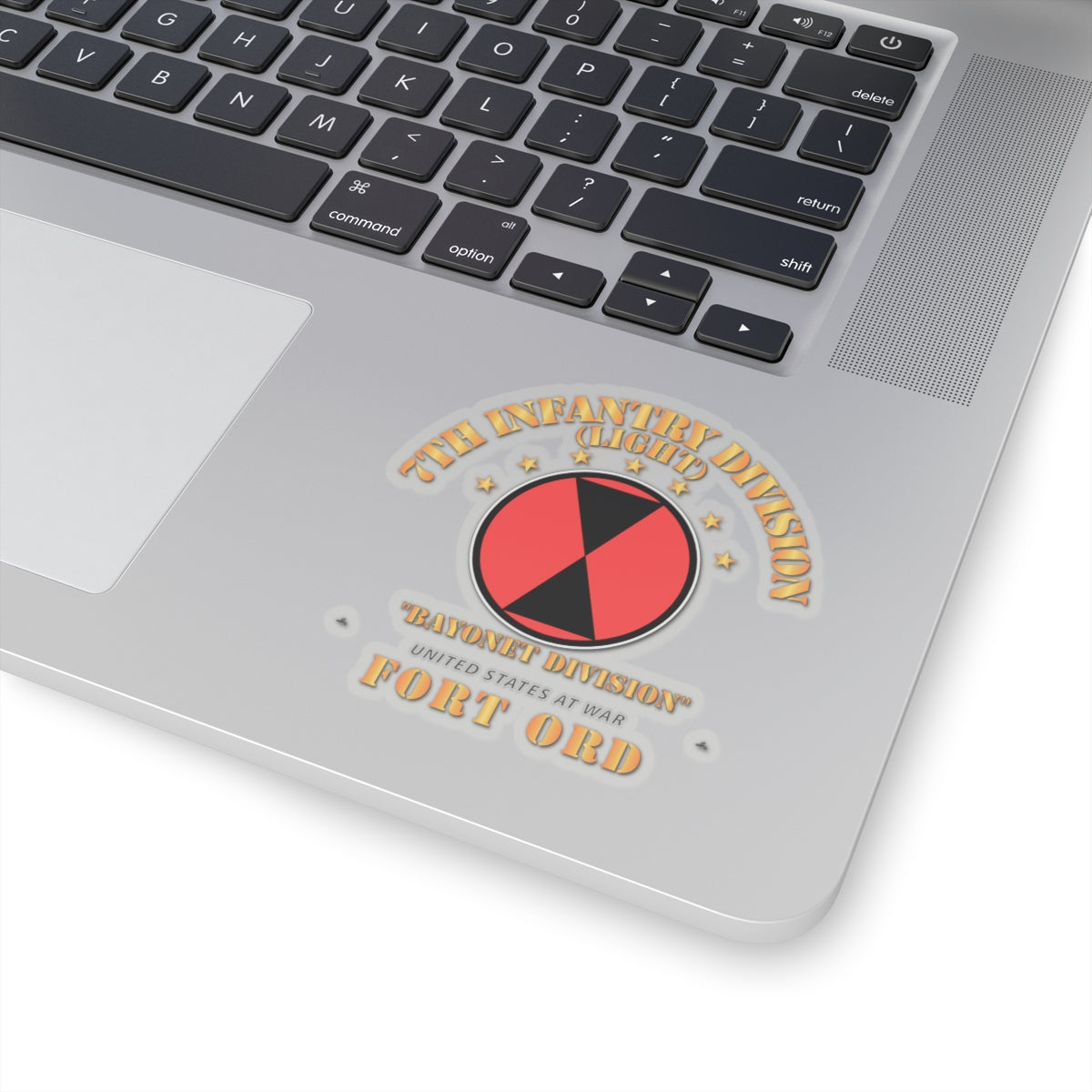 Laptop with a sticker on the palm rest area featuring a red and black circular design.