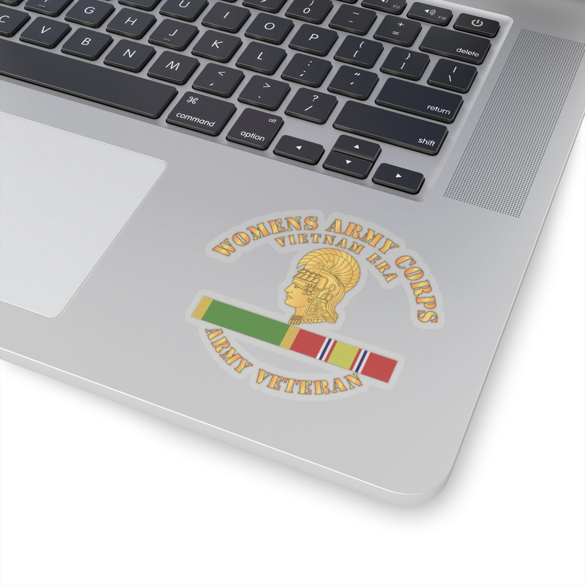A sticker with the Women's Army Corps Vietnam Era logo, featuring a gold-colored emblem and a ribbon.