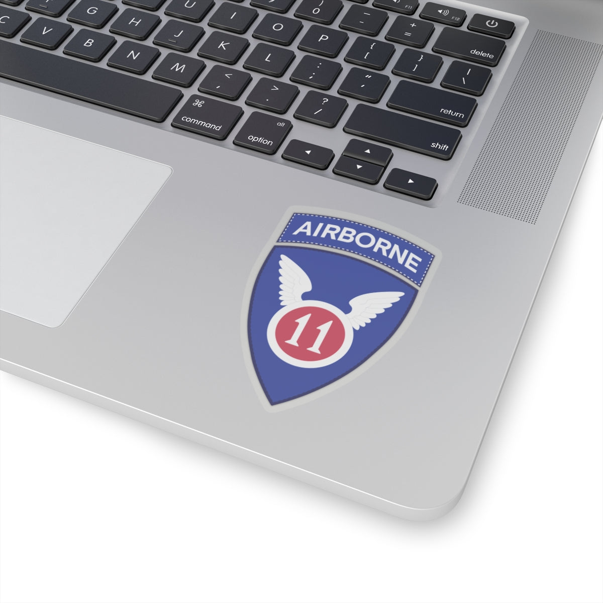 A kiss-Cut Stickers depicting the The 11th Airborne Division, known as the "Angels," is a historic U.S. Army airborne unit. Its shoulder sleeve insignia (SSI) features a red winged sword (symbolizing speed and striking power) on a blue background with a white border.