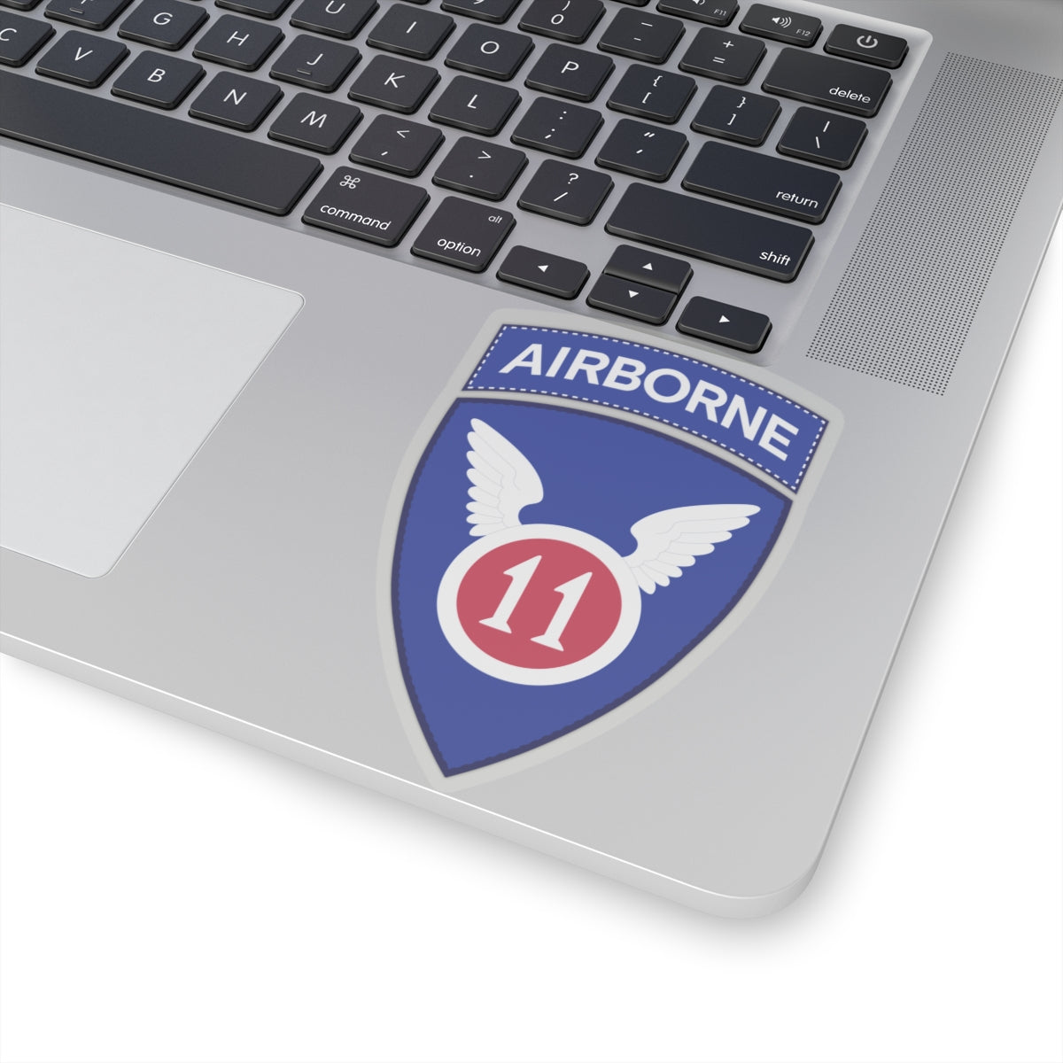 A kiss-Cut Stickers depicting the The 11th Airborne Division, known as the "Angels," is a historic U.S. Army airborne unit. Its shoulder sleeve insignia (SSI) features a red winged sword (symbolizing speed and striking power) on a blue background with a white border.