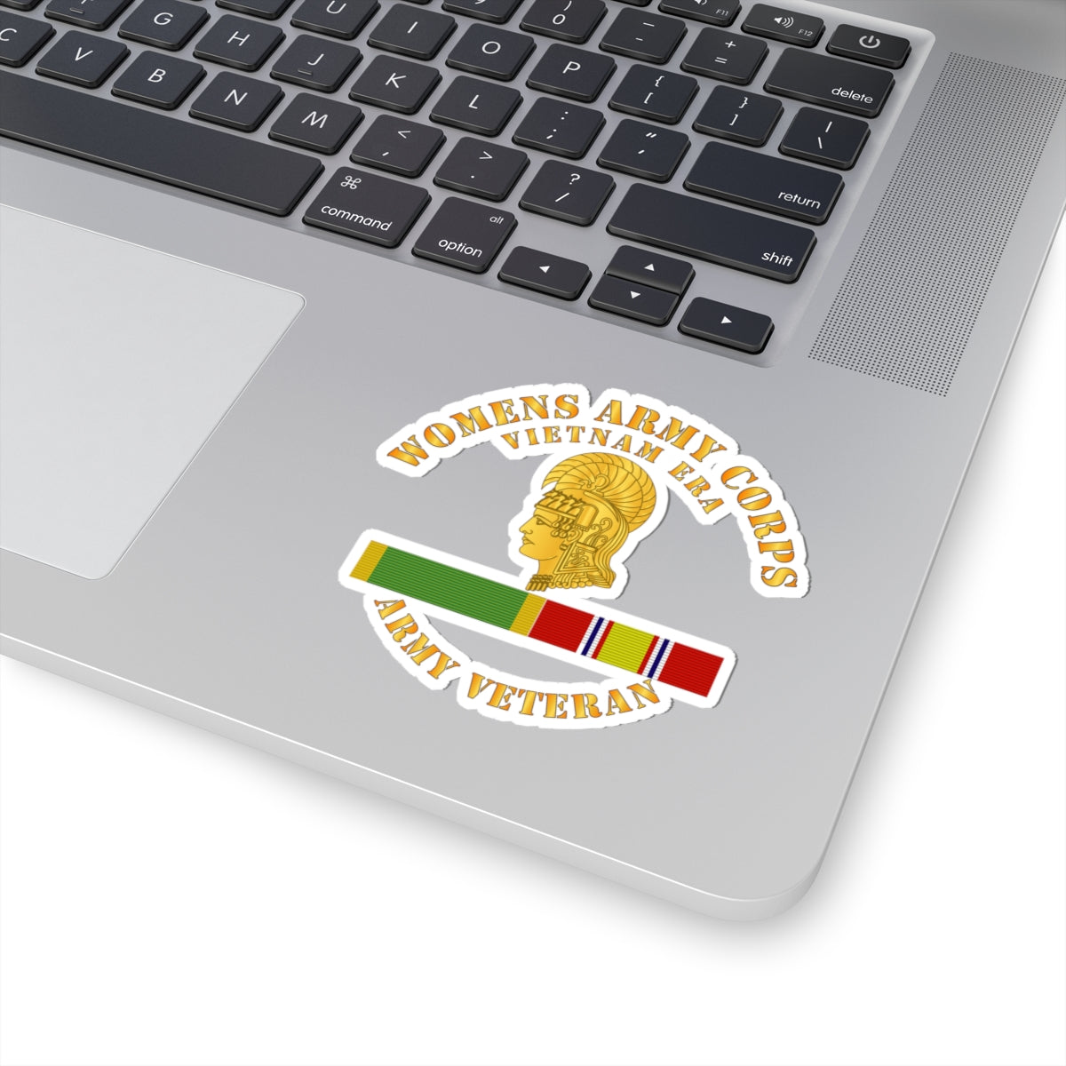 A sticker with the Women's Army Corps Vietnam Era logo, featuring a gold-colored emblem and a ribbon.
