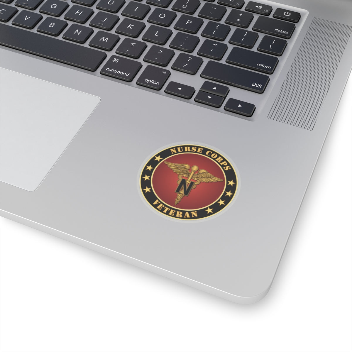 A circular sticker with a red background featuring the caduceus symbol, stars, and the text 'NURSE CORPS VETERAN'. The sticker has a golden border.