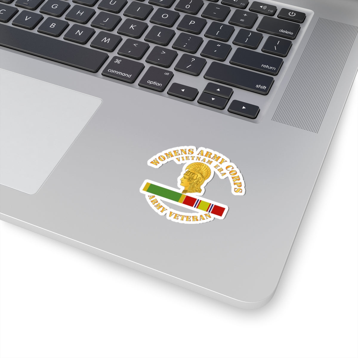 A sticker with the Women's Army Corps Vietnam Era logo, featuring a gold-colored emblem and a ribbon.