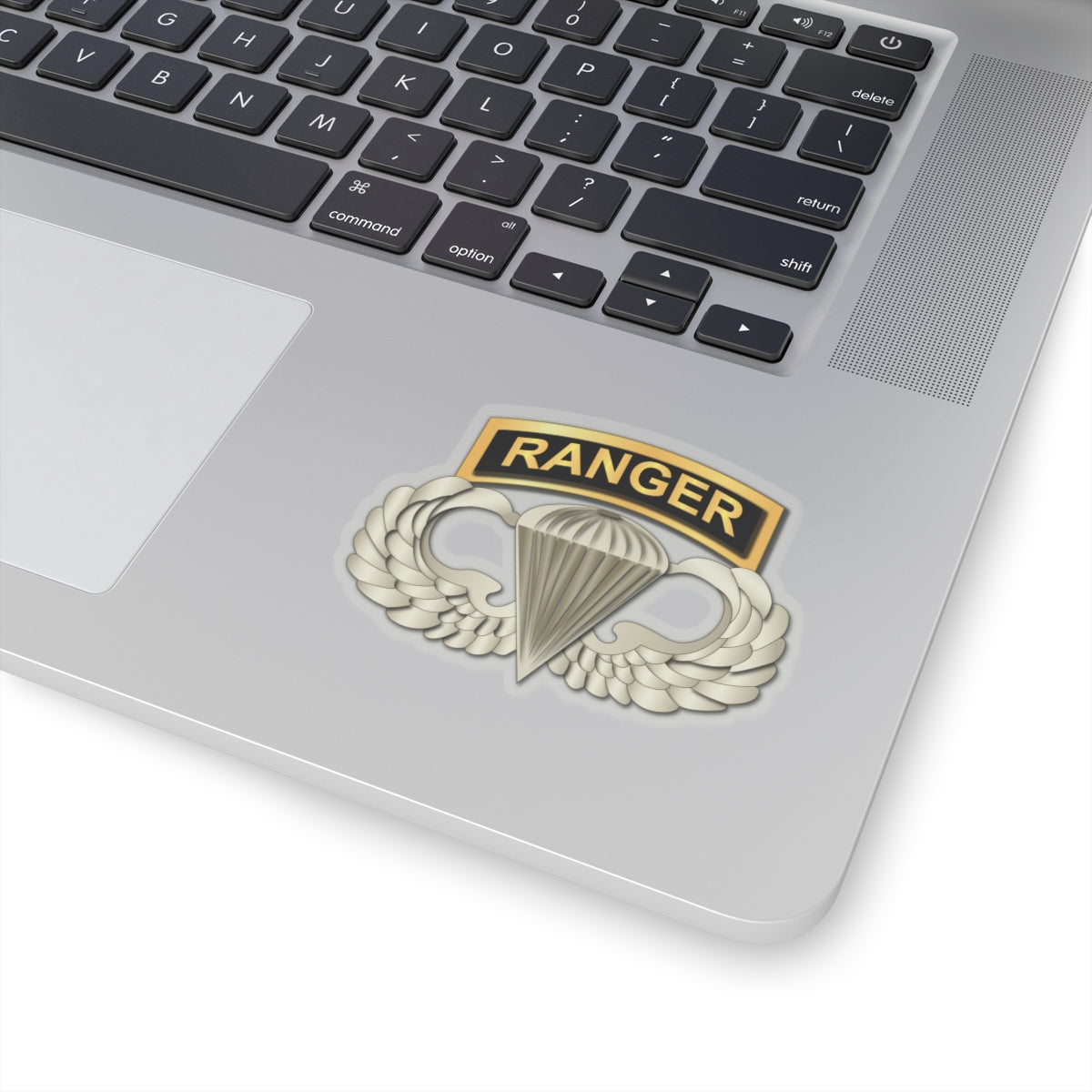 A sticker with a gold-colored ribbon labeled 'RANGER' above a wings and parachute design, signifying the Airborne Badge.